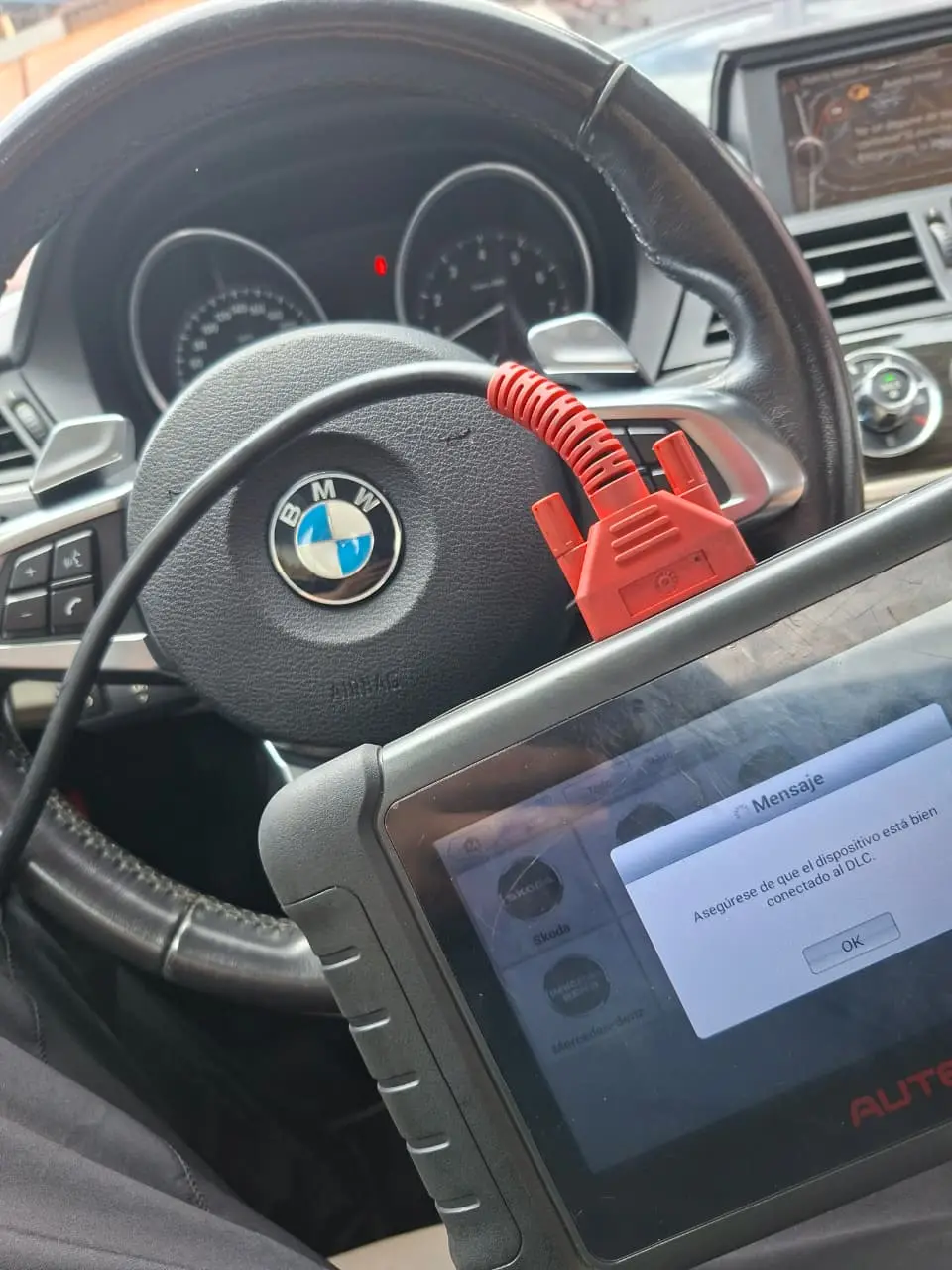 Escáner Autel conectado a un BMW, leyendo los módulos del vehículo