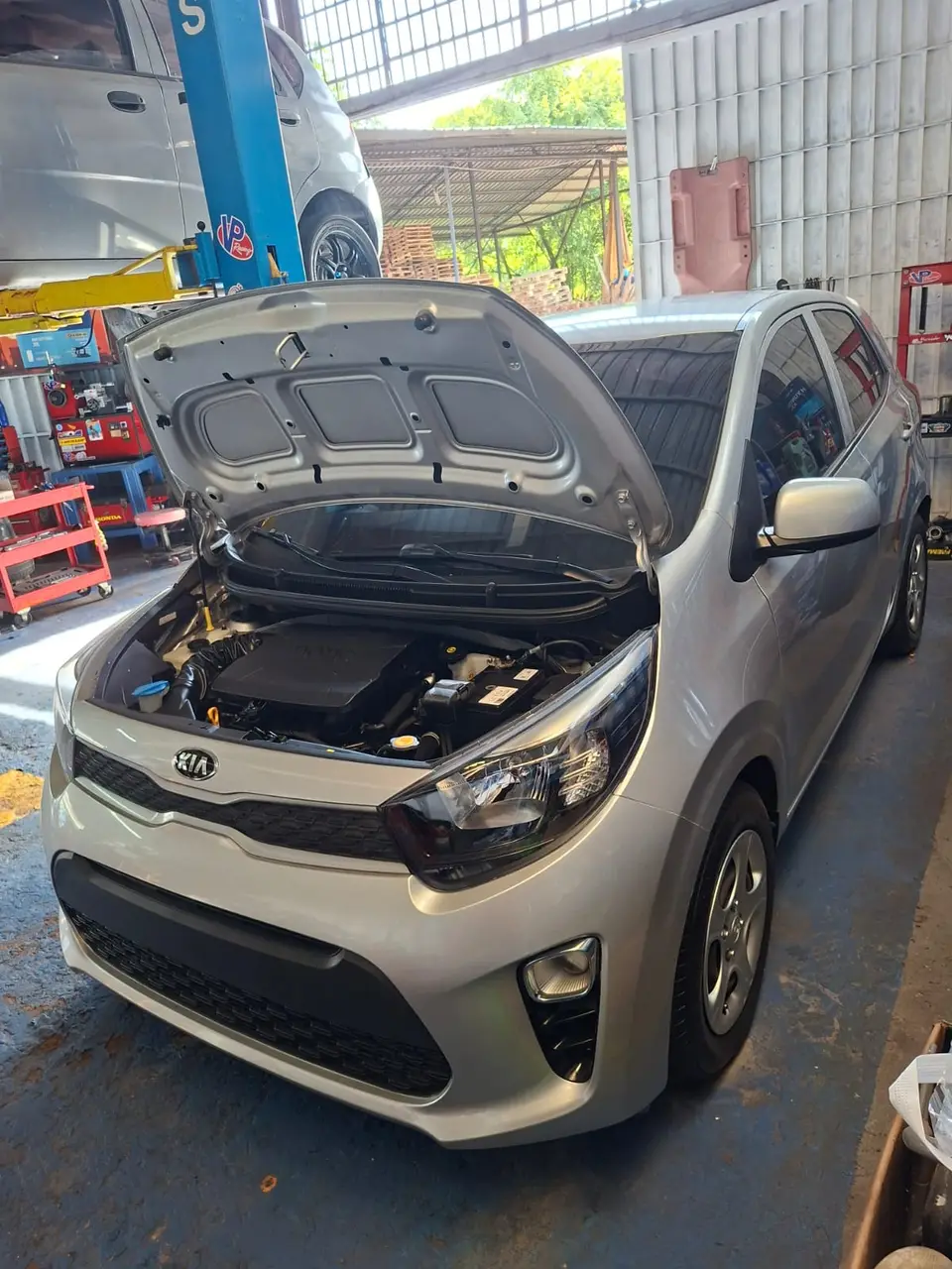 Kia con el capó abierto durante una revisión