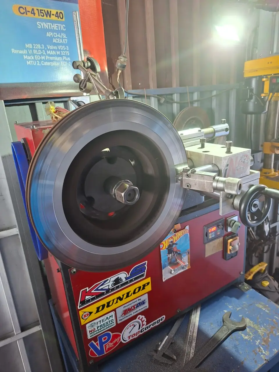 Rectificadora de discos de freno en el taller, con el logo de Top Garage en la máquina